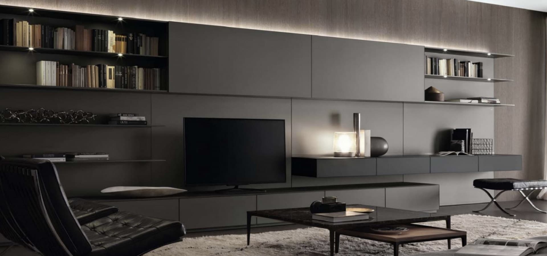 Tv-wand op maat in mat zwart en bruingrijs, met open vakken, laden en een zwevend dressoir