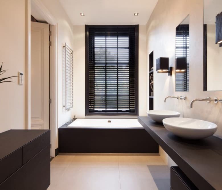 Lichte badkamer met een greeploos badmeubel in donker eiken, een opzetwaskom en houten shutters