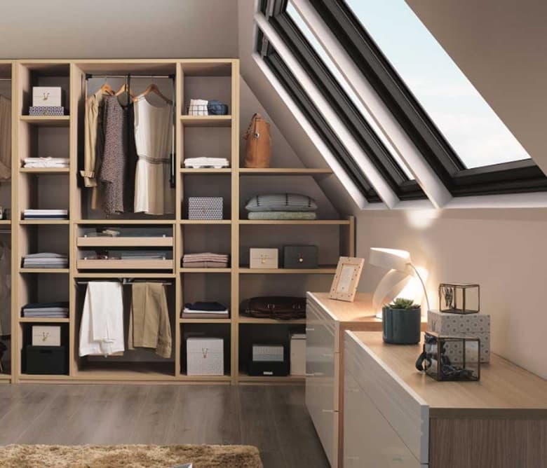 Dressing onder een schuin dak met dakramen, uitgevoerd in licht hout met open vakken en een bureau