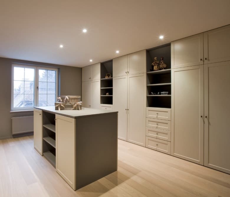 Dressing in gelakt spuitwerk met een gesloten kastwand en een vrijstaand eiland met lades