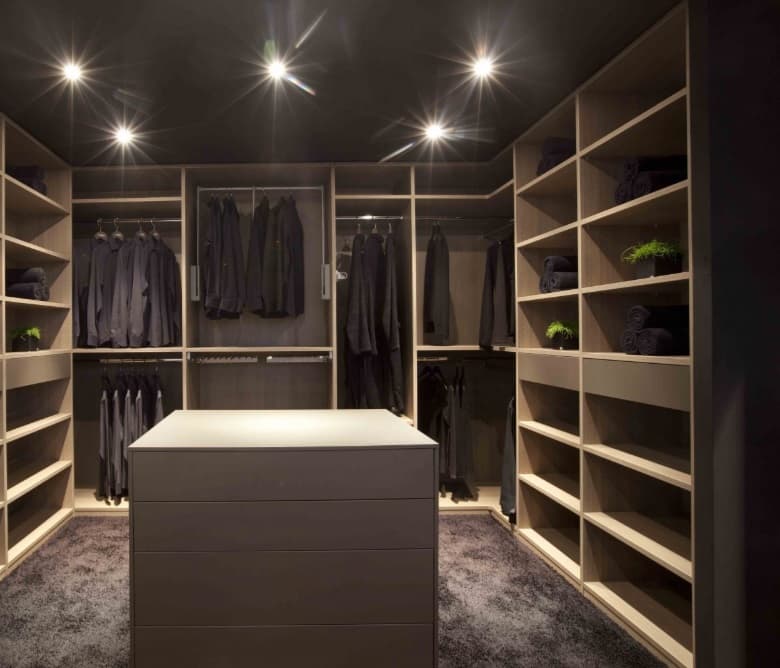 Dressing in donkere tinten met een centraal eiland, hangroedes en inbouwspots
