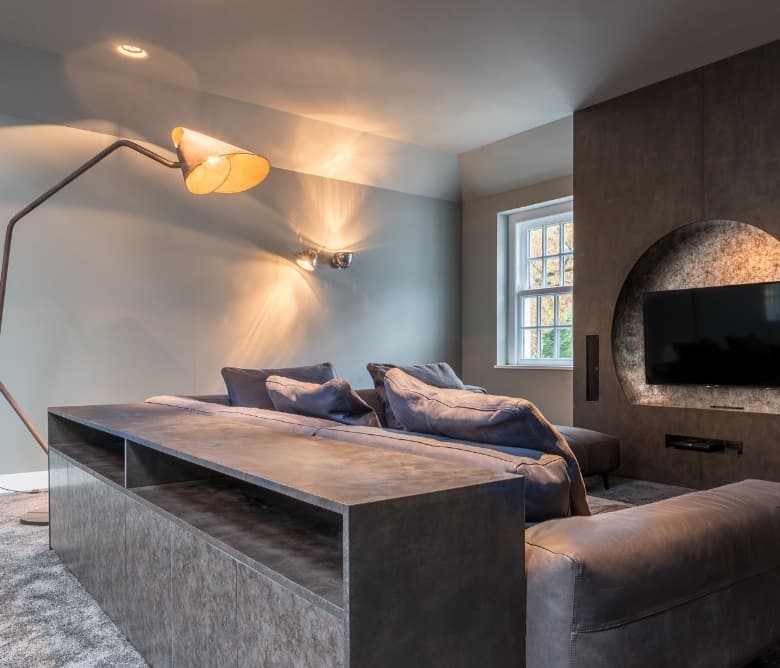 Loungeruimte met maatwerk wandbekleding in donker hout en een televisie in een nis